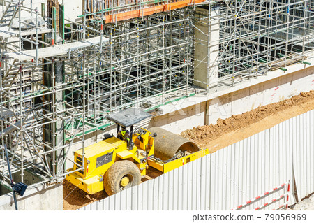 Modern building is under construction, metal scaffolding and blue sky 79056969