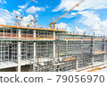 Modern building is under construction, metal scaffolding and blue sky 79056970