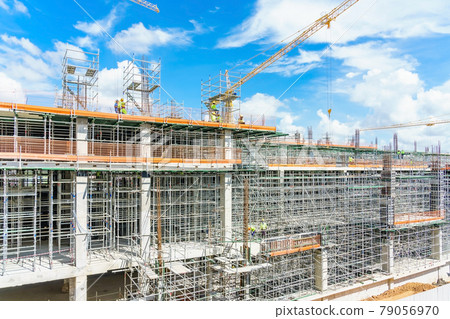 Modern building is under construction, metal scaffolding and blue sky 79056970