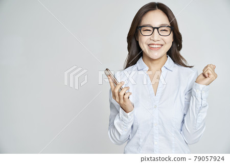 Glasses, smartphone, young woman, business woman, career woman, nude, gray background Glasses, smartphone, young woman, business woman, career woman, nude, gray background 79057924