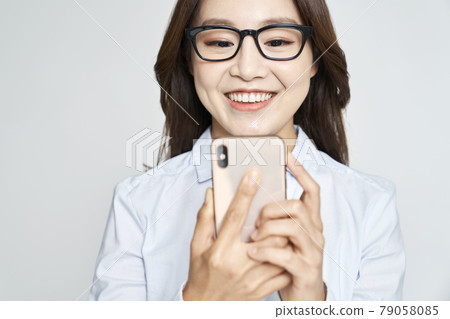Glasses, smartphone, young woman, business woman, career woman, nude, gray background 79058085