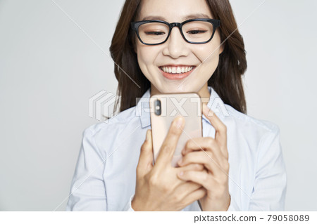 Glasses, smartphone, young woman, business woman, career woman, nude, gray background Glasses, smartphone, young woman, business woman, career woman, nude, gray background 79058089