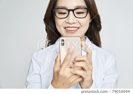 Glasses, smartphone, young woman, business woman, career woman, nude, gray background 79058094