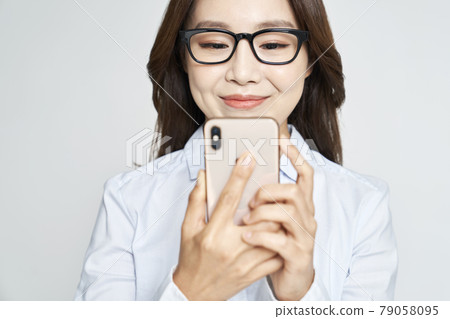 Glasses, smartphone, young woman, business woman, career woman, nude, gray background Glasses, smartphone, young woman, business woman, career woman, nude, gray background 79058095