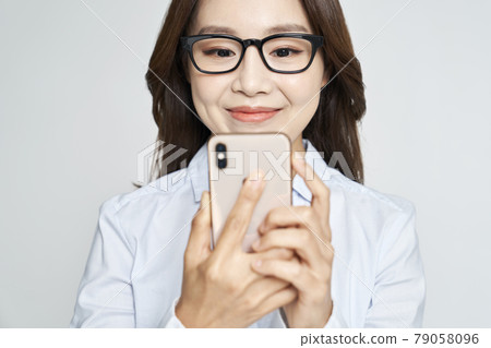 Glasses, smartphone, young woman, business woman, career woman, nude, gray background 79058096