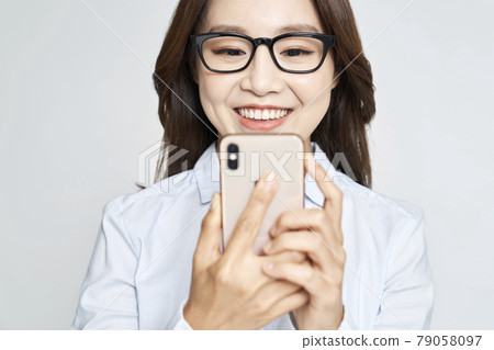 Glasses, smartphone, young woman, business woman, career woman, nude, gray background Glasses, smartphone, young woman, business woman, career woman, nude, gray background 79058097