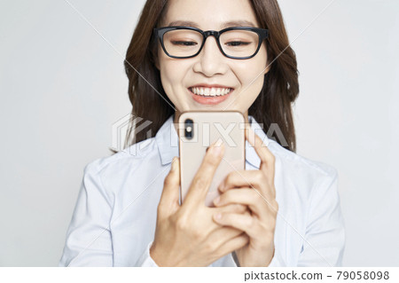 Glasses, smartphone, young woman, business woman, career woman, nude, gray background 79058098