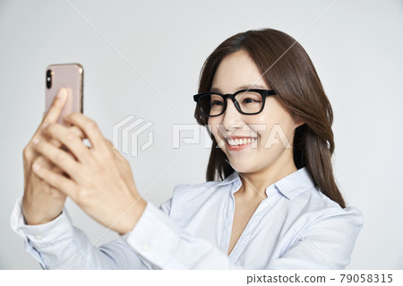 Glasses, smartphone, young woman, business woman, career woman, nude, gray background Glasses, smartphone, young woman, business woman, career woman, nude, gray background 79058315