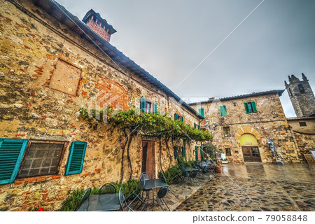Tables and chairs in Monteriggioni main square 79058848