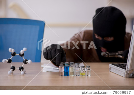 Young man in balaclava stealing vaccine from the lab 79059957