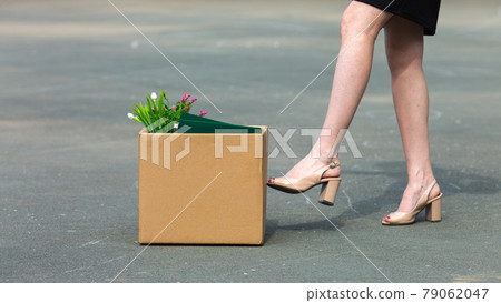 A woman's foot kicks a box of personal belongings after being fired close-up A woman's foot kicks a box of personal belongings after being fired close-up 79062047