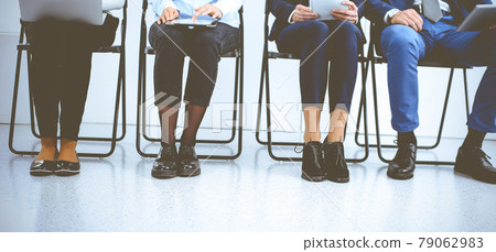 Group of business people sitting in office and waiting for job interview while using gadgets. Conference or training concepts Group of business people sitting in office and waiting for job interview while using gadgets. Conference or training concepts 79062983