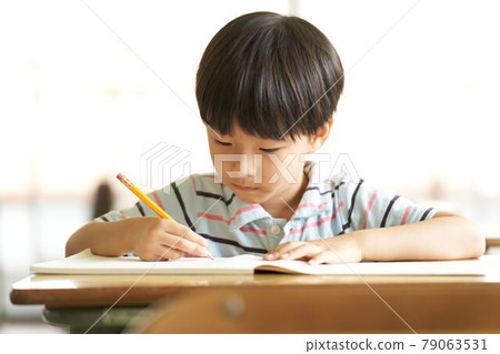 Little boy studying with a pencil Little boy studying with a pencil 79063531