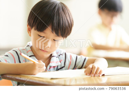 Little boy studying with a pencil Little boy studying with a pencil 79063536