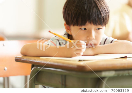 Little boy studying with a pencil 79063539
