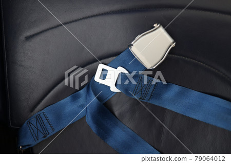Safety belts lying on passenger seat of aircraft closeup Safety belts lying on passenger seat of aircraft closeup 79064012
