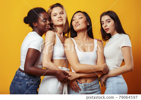diverse multi nation girls group, teenage friends company cheerful having fun, happy smiling, cute posing on yellow background, lifestyle people concept, african-american, asian and caucasian 79064597