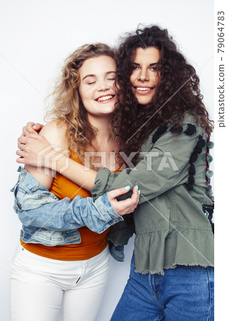young pretty teenage girls friends with blond and brunette curly hairs posing cheerful isolated on white background, lifestyle people concept young pretty teenage girls friends with blond and brunette curly hairs posing cheerful isolated on white background, lifestyle people concept 79064783