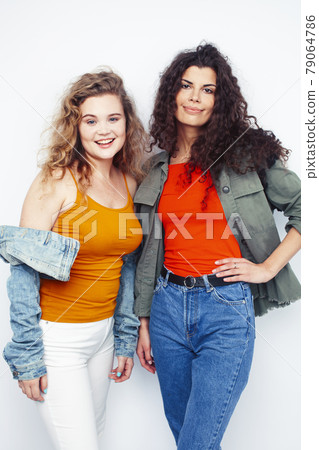 young pretty teenage girls friends with blond and brunette curly hairs posing cheerful isolated on white background, lifestyle people concept young pretty teenage girls friends with blond and brunette curly hairs posing cheerful isolated on white background, lifestyle people concept 79064786