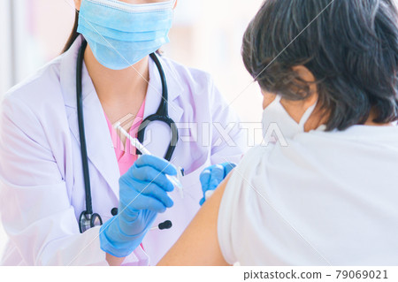 Female doctor vaccinating seniors Female doctor vaccinating seniors 79069021