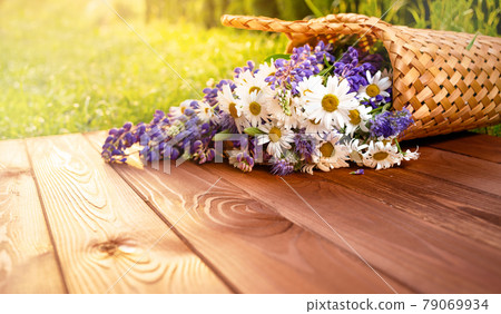 Beautiful summer flowers in a basket on a wooden patio 79069934
