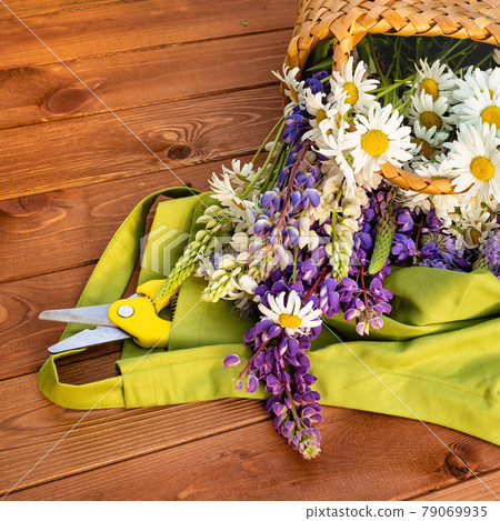 Beautiful summer flowers in a basket on a wooden patio Beautiful summer flowers in a basket on a wooden patio 79069935