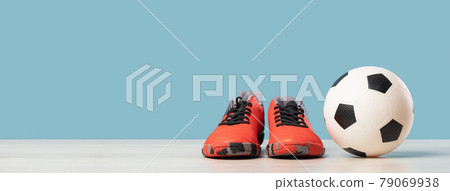 Soccer ball and cleats on blue background. Football Soccer ball and cleats on blue background. Football 79069938