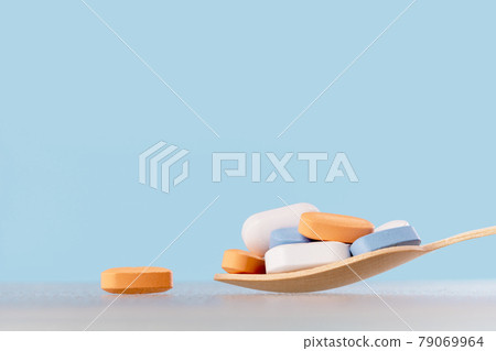 Background of white tablets or pills on blue table. Medicine and pharmacy 79069964