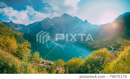 Tatra National Park, Poland. Famous Mountains Lake Morskie Oko Or Sea Eye Lake In Summer Evening. Beautiful Sunset Sun Sunshine Sunrays Above Tatras Lake Landscape Tatra National Park, Poland. Famous Mountains Lake Morskie Oko Or Sea Eye Lake In Summer Evening. Beautiful Sunset Sun Sunshine Sunrays Above Tatras Lake Landscape 79070178
