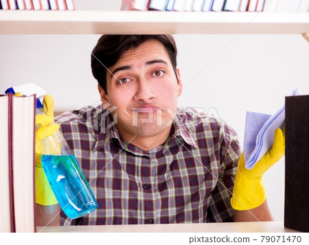 Man cleaning dust from bookshelf Man cleaning dust from bookshelf 79071470