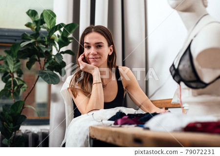 Female fashion designer sits in her workplace Female fashion designer sits in her workplace 79072231