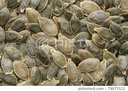 Green pumpkin seeds background, top view, flat lay. Green pumpkin seeds background, top view, flat lay. 79075322