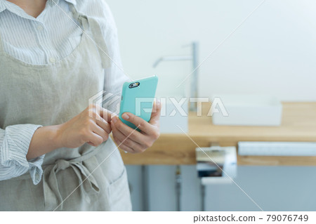 Hand of a person with a smartphone in the toilet 79076749