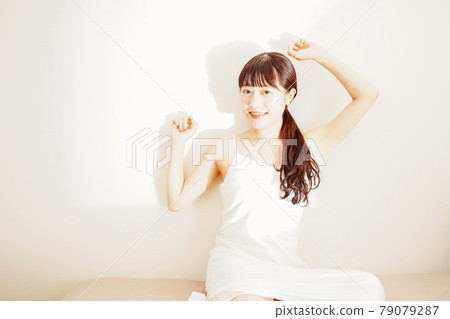 在早晨的陽光下醒來的年輕女人 79079287