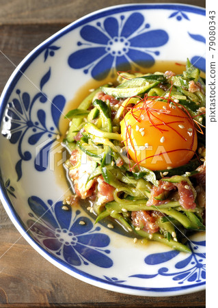 A bird's-eye view of cucumber and raw ham yukke with egg yolk, red pepper and sesame seeds A bird's-eye view of cucumber and raw ham yukke with egg yolk, red pepper and sesame seeds 79080343