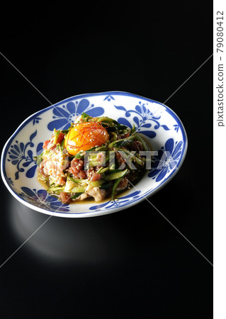 Photographed cucumber and prosciutto ham with egg yolk, red pepper and sesame seeds on a black background 79080412