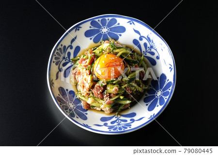 A bird's-eye view of the cucumber and prosciutto ham with egg yolk, red pepper and sesame seeds on a black background A bird's-eye view of the cucumber and prosciutto ham with egg yolk, red pepper and sesame seeds on a black background 79080445