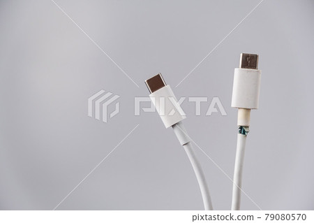 Close-up of a torn and intact type C mobile phone charging wire. Close-up of a torn and intact type C mobile phone charging wire. 79080570