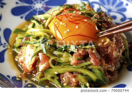 Cucumber with red pepper and sesame seeds and egg yolk on prosciutto ham 79080744