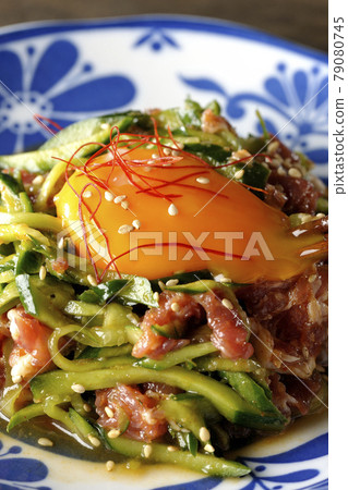 Cucumber with red pepper and sesame seeds and egg yolk on prosciutto ham 79080745