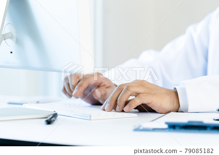 At the hands of a doctor heading to a computer 79085182