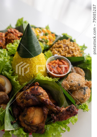 nasi tumpeng. indonesian cuisine yellow rice on banana leaf nasi tumpeng. indonesian cuisine yellow rice on banana leaf 79085287