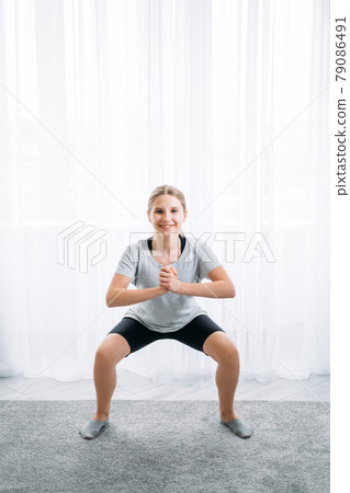 home sport kids fitness training girl doing squat 79086491