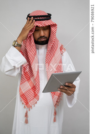 an arab in a turban is dizzy while using a pad 79086921