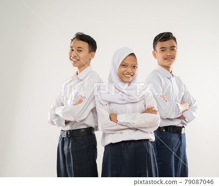 Three teenagers in junior high school uniforms stand smiling with crossed hands Three teenagers in junior high school uniforms stand smiling with crossed hands 79087046