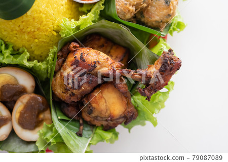 nasi tumpeng. indonesian cuisine yellow rice on banana leaf 79087089