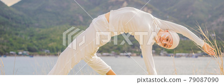 BANNER, LONG FORMAT Kundalini yoga woman in white clothes and turban practices yoga kundalini on the background of the sea, mountains and sunset. Fighting face painting of the Indians shows her inner BANNER, LONG FORMAT Kundalini yoga woman in white clothes and turban practices yoga kundalini on the background of the sea, mountains and sunset. Fighting face painting of the Indians shows her inner 79087090