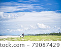 Parents and children taking a walk on the sandy beach 79087429