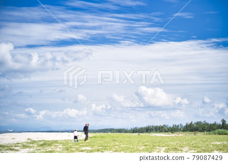 Parents and children taking a walk on the sandy beach Parents and children taking a walk on the sandy beach 79087429