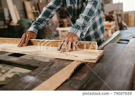 Carpenter Cutting with Circular Saw 79087689